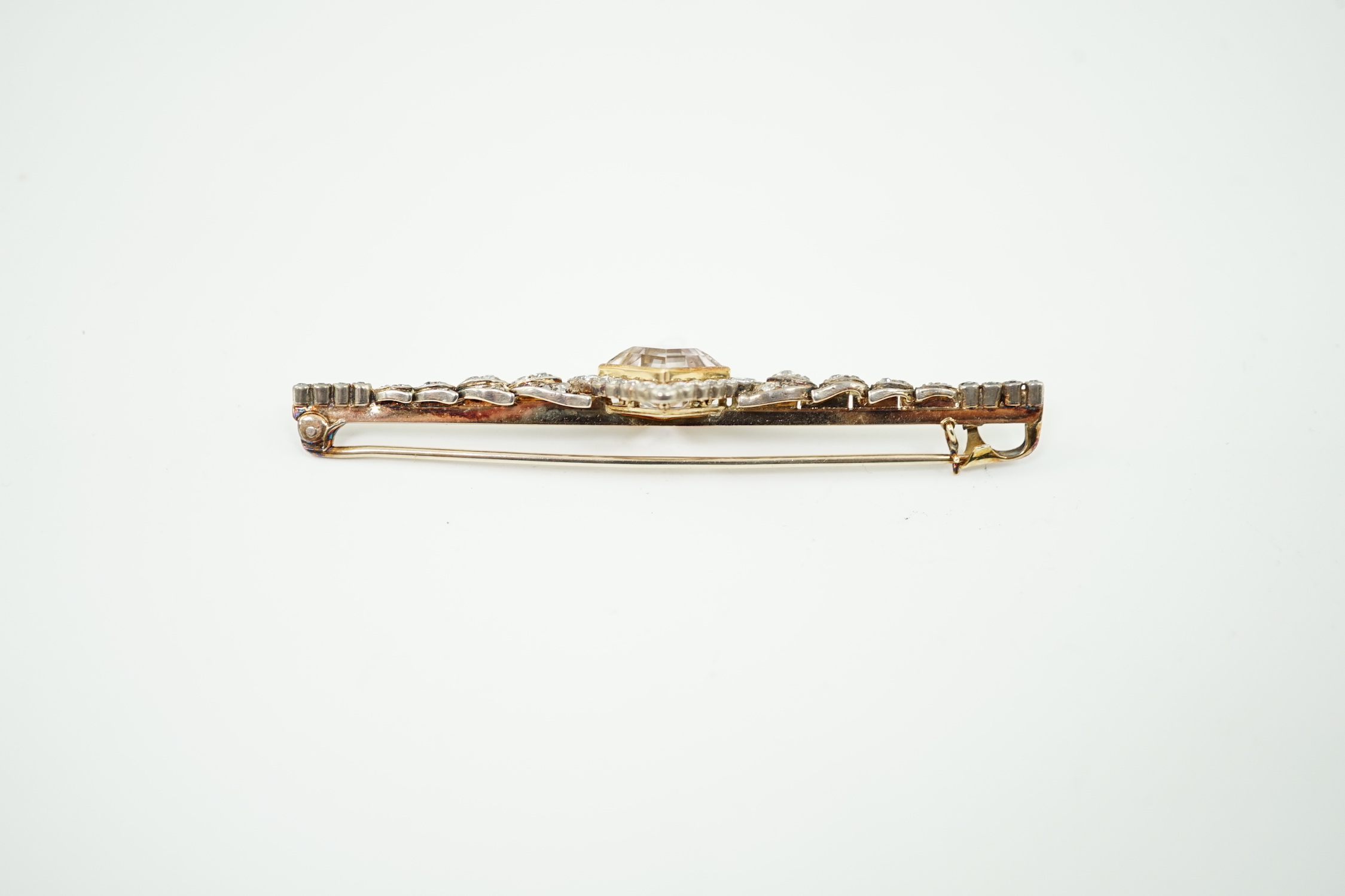 An early to mid 20th century gold and silver, pale pink topaz and millegrain set diamond cluster bar brooch